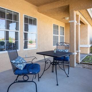A cozy patio setup with a table and two cushioned chairs.