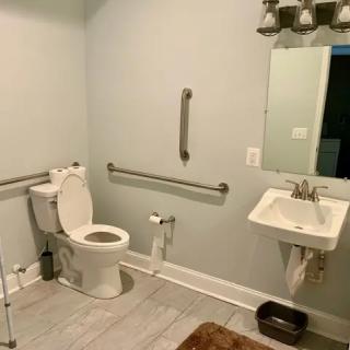 Accessible bathroom with grab bars and standard fixtures.