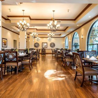 Elegant dining area with chandeliers and wooden flooring.