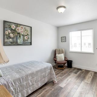 A cozy bedroom with a single bed, rocking chair, and a window letting in natural light.