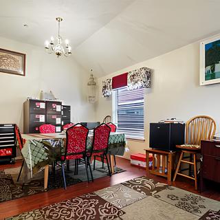 A cozy dining room with a large table, colorful chairs, and decorative elements.