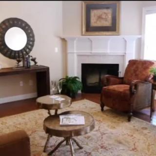 Cozy living room with a fireplace, featuring an armchair, coffee tables, and stylish decor.
