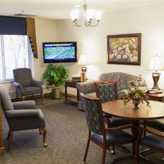 A cozy living room with a sofa, chairs, and a television.
