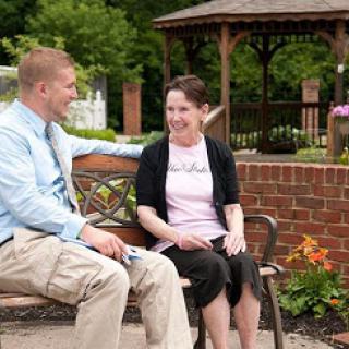 Two friends enjoying a pleasant conversation on a park bench.