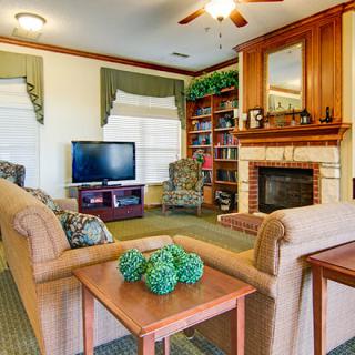 Cozy living room with a fireplace, seating area, and integrated bookshelf.