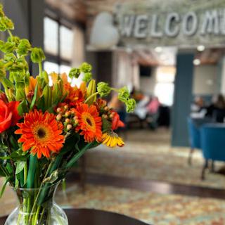 A vibrant bouquet of flowers welcomes guests in a cozy interior setting.