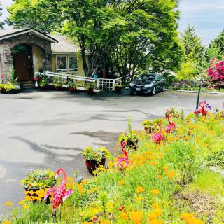 A charming house with a beautifully landscaped garden featuring colorful flowers and trees.