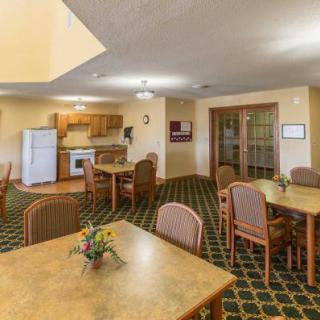 A cozy communal dining area with a kitchen space, tables, and chairs.