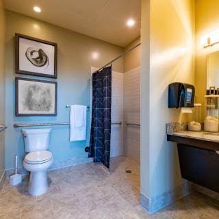 A modern bathroom with a toilet, sink, and walk-in shower.