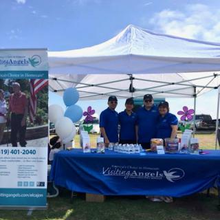 A team at a community event showcasing their booth with information and resources.