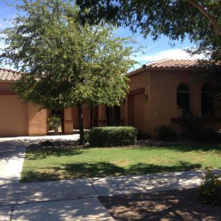 A suburban house with a driveway and surrounding trees.