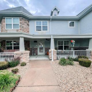 A beautifully designed residential building with welcoming landscaping and a charming front entrance.