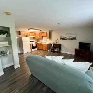 A cozy open-concept living area featuring a comfortable couch and a well-equipped kitchen.