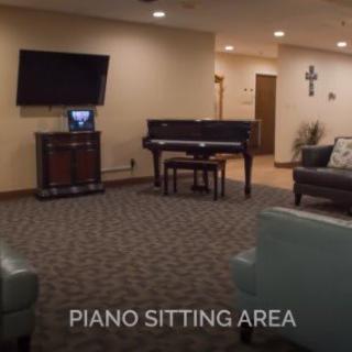 A cozy sitting area with a piano and television.