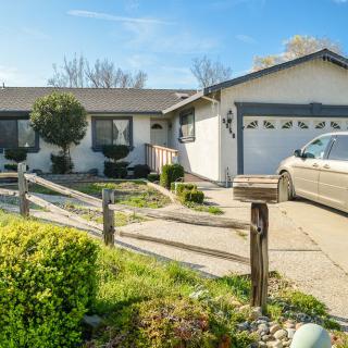 A suburban house with a driveway leading to a garage and well-maintained front yard.