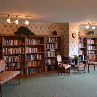 A cozy library with bookshelves and seating arrangements.