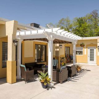 A sunny patio with a pergola and outdoor seating area.
