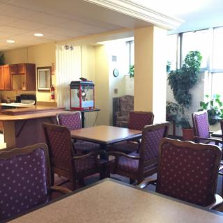 A brightly lit dining area with multiple tables and chairs.