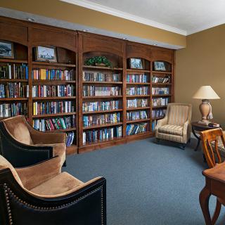A cozy library room with bookshelves and comfortable seating.