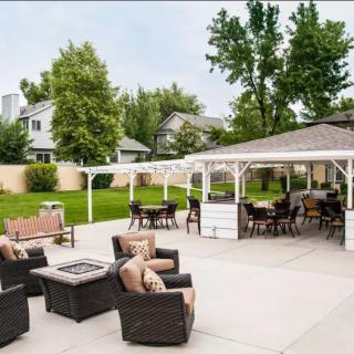A spacious backyard patio with comfortable outdoor seating, a gazebo, and a fire pit.