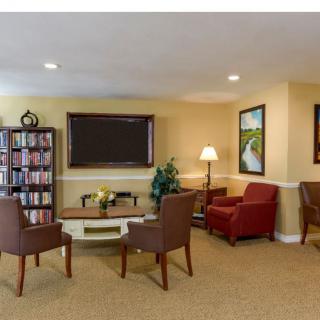 A cozy living room with comfortable seating, a television, and a bookshelf.