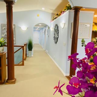 A stylish hallway with decorative columns, vibrant flowers, and elegant interior design.