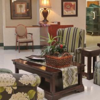 A cozy living room area with a variety of furniture and decorative elements.
