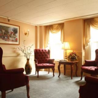 A cozy living room with traditional armchairs, a central table, and elegant decor.