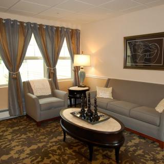 A cozy living room with a sofa, armchair, and elegant decor.