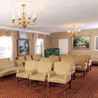 A furnished room with arranged seating and decorative paintings.