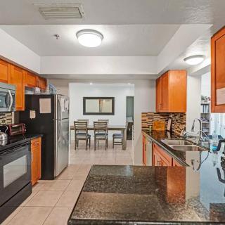 A modern kitchen with wood cabinets and an adjacent dining area.