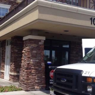 Entrance of a commercial building with a truck parked nearby.