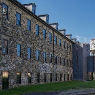A historic stone building with multiple windows and a clear sky in the background.