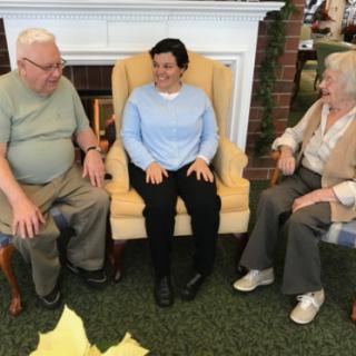 A friendly gathering of three seniors enjoying a moment together in a cozy indoor setting.