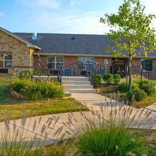 A charming house with a well-landscaped garden and a pathway leading to the entrance.
