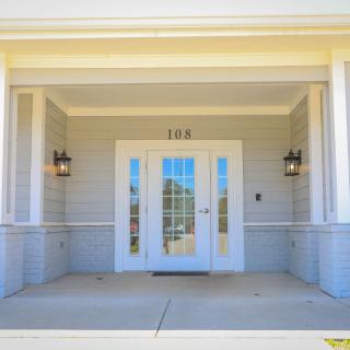 A front entrance with double doors and sidelights, framed by a covered porch area.