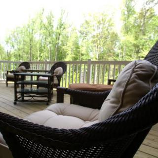 Cozy outdoor seating area on a deck surrounded by nature.