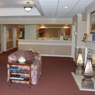 A cozy lobby with a reception desk, comfortable seating, and warm lighting.
