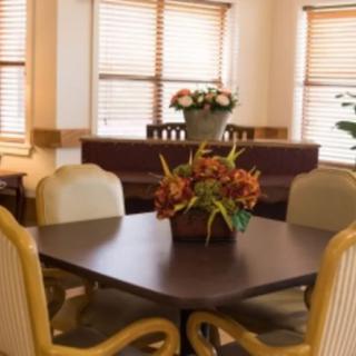 A cozy dining area with a table, chairs, and floral decorations.