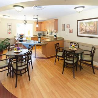 An inviting kitchen and dining area with wooden flooring and neatly arranged furniture.