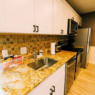 A modern kitchen with granite countertops and stainless steel appliances.