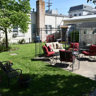 A cozy backyard setup with comfortable seating and a lush green lawn.