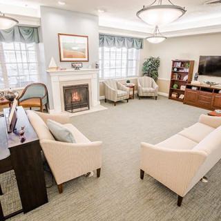 A cozy and modern living room with a fireplace, comfortable seating, and a television.