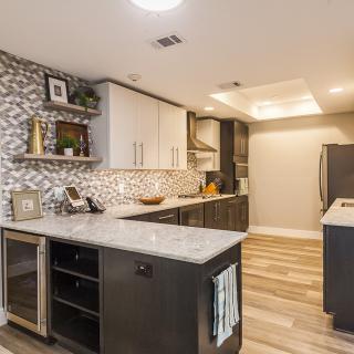 A modern kitchen with a stylish backsplash and marble countertops.