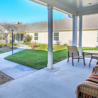 A cozy backyard patio with outdoor seating and a well-maintained lawn.