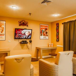 A cozy lounge with comfortable seating and a television, decorated with vintage posters.