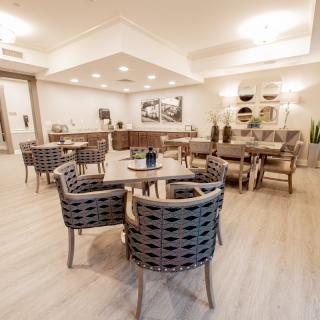A modern dining area with wicker chairs and wooden tables, complemented by stylish lighting.