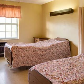 A simple bedroom with two beds and a window.