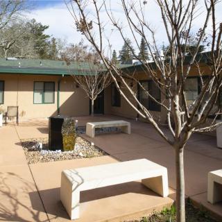 A serene courtyard featuring benches and leafless trees surrounded by a building.
