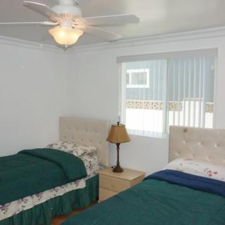 A cozy bedroom with twin beds and a ceiling fan.